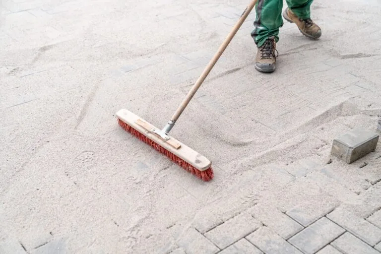 Interlink team brushing kiln dried sand into recently completed block paving driveway in Liverpool